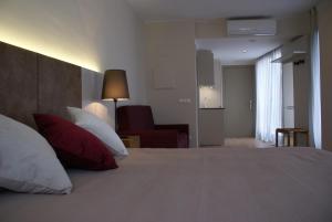 菲格拉斯K公寓酒店的一间卧室配有一张带红色和白色枕头的大床