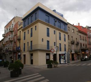 菲格拉斯K公寓酒店的城市街道上一座蓝色屋顶的建筑