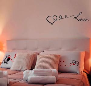 洛科罗通多Deluxe Alba的卧室配有一张墙上有一句爱的话的床