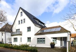 居特斯洛Lichtdurchflutetes Design - Appartement Gütersloh - 90 qm的屋顶上设有太阳能电池板的白色房子