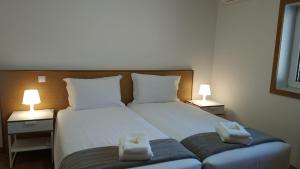 阿鲁卡Central Suites Arouca的酒店客房,配有两张带毛巾的床