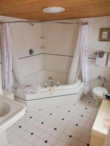 伯利恒阿代尔乡村餐厅旅馆的白色的浴室设有浴缸和卫生间。