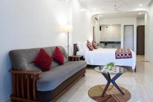 坎多林SHANU'S SEASIDE INN - A Guesthouse, 100 metres to Candolim Beach的客厅配有沙发和1张床