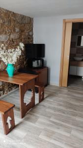 帕德隆Albergue con encanto d'camiño的客厅配有木桌和电视。
