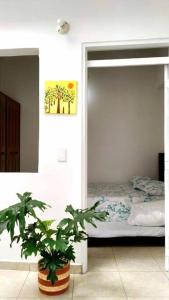 拉特瓦伊达Apartamento amoblado en La Tebaida, Quindio的一间卧室配有一张床和盆栽植物
