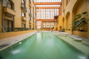 蒙特雷蒙特雷卡米奥真实酒店的一座带大窗户的建筑中的游泳池