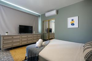 圣胡安La Buena Vida Inn的一间卧室配有一张床和一台平面电视