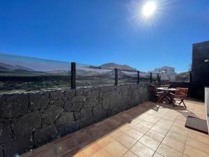 La VeguetaEslanzarote Casa Carait, Super wifi, Sat tv的庭院内带桌椅的石墙