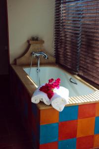 勒弗朗索瓦La Perle du Lagon的浴室内装有鲜花的色彩缤纷的浴缸