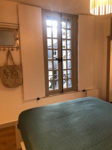 坎佩尔Au COCON QUIMPEROIS的一间卧室设有一张绿色的床和一个窗户。