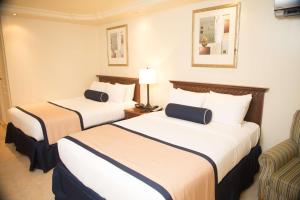 巴拿马城巴拿马城江山旅馆的酒店客房,配有两张床和椅子
