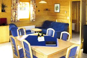 斯利耶巴赫Holiday Village Schlierbach的一间带桌子和蓝色沙发的用餐室