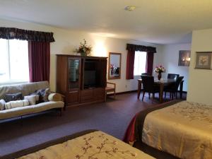 奇斯顿Keystone Boardwalk Inn and Suites的酒店客房配有床、沙发和桌子。