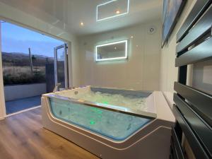 威廉堡Highland Stays - Ben View Room & Jacuzzi Bath的一个带窗户的客房内的按摩浴缸
