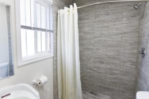 英格尔伍德Holly Park Motel near LAX的浴室配有淋浴帘和盥洗盆。