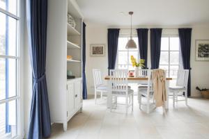 富伦多夫Holiday house, Fuhlendorf的一间设有蓝色窗帘和桌椅的用餐室