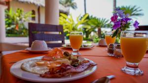 巴亚尔塔港巴亚尔塔港热带花园酒店的一张桌子,上面放着一盘食物和两杯橙汁