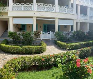 拉斯特拉纳斯La Dolce Vita Beachfront Apt 2的一座带鲜花和灌木庭院的建筑