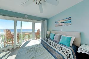 卡罗来纳比奇Oceanfront Townhouse的一间卧室设有一张床和一个海景阳台