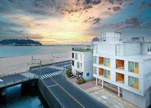 镰仓市HOTEL AO KAMAKURA的毗邻海滩的一座建筑