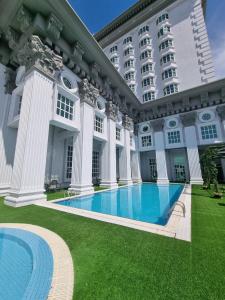马六甲Grand Swiss-Belhotel Melaka - formerly LaCrista Hotel Melaka的一座大型建筑,前面设有一个游泳池