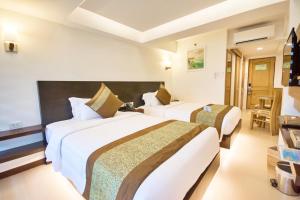 长滩岛Commander Suites de Boracay的一间酒店客房,房间内设有两张床