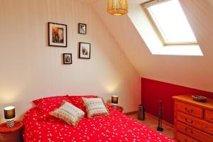 BruchevilleSemi-detached house, Brucheville的一间卧室配有红色的床和枕头