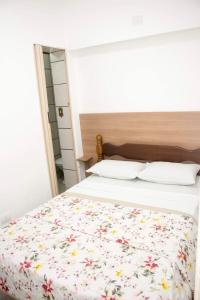 瓜鲁雅Hotel Morada do Mar的一间卧室配有一张带花卉床罩的床