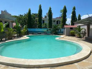 蒙巴萨Mudzini gardens - Luxury villa with a pool的一座树木繁茂的庭院内的游泳池