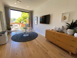 悉尼The Mitchell Bondi Sun Terrace 2的客厅配有桌子和电视