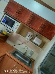 卢穆特Apartment Teluk Batik的厨房配有水槽和微波炉