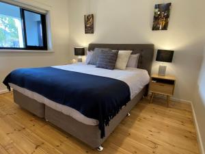 悉尼The Mitchell Bondi Garden 4的一间卧室配有一张带蓝色毯子的大床