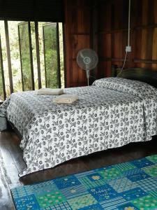 Kampung Hulu Calukthesanctuary@telagapapan的一间卧室配有一张床和一个风扇。