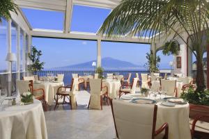 索伦托安巴夏托理大酒店的一间设有桌椅的海景餐厅