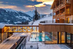 多弗加斯坦Berghotel Hauserbauer的雪中带游泳池的酒店
