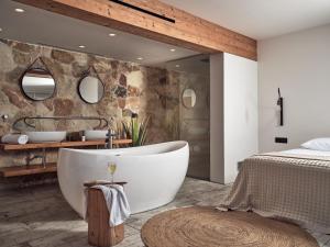 拉加纳斯格里亚马里斯酒店套房及别墅的卧室内带大浴缸的浴室