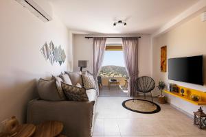 特里欧皮特拉Villa Mariva , south Crete , Triopetra的带沙发和电视的客厅
