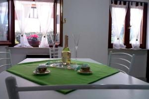 托尔托利Appartamento La Rocca的一张桌子,上面放着一瓶葡萄酒,放在绿色餐巾上