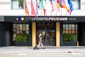 米兰City Life Hotel Poliziano, by R Collection Hotels的站在有旗帜的建筑前走的女人