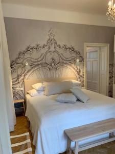 格拉茨White Flat by GrazRentals with cool location & free parking的卧室配有一张白色的床和大型床头板