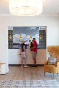 科尔斯万特Dorint Resort Baltic Hills Usedom的两人站在客厅的柜台上