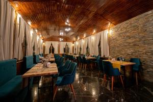 锡纳亚库姆帕特酒店的餐厅设有长桌和蓝色椅子