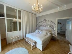 格拉茨White Flat by GrazRentals with cool location & free parking的卧室配有一张白色大床和吊灯。