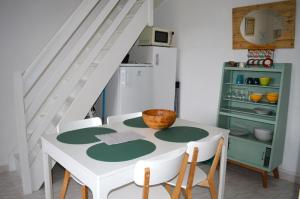 库尔瑟勒·苏尔·梅尔Triplex avec jardinet - wifi - à 400m de la plage的一间带桌椅和楼梯的厨房
