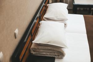 切尔诺夫策乔治帕勒斯酒店的一张带白色床单和枕头的床