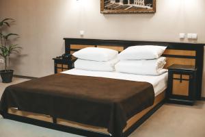 切尔诺夫策乔治帕勒斯酒店的一间卧室配有带白色床单和枕头的床。