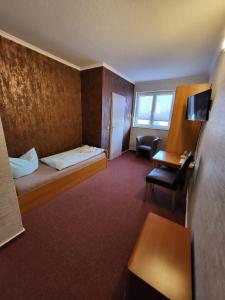 罗斯多夫Appart Hotel Roßdorf的配有一张床和一张书桌的酒店客房