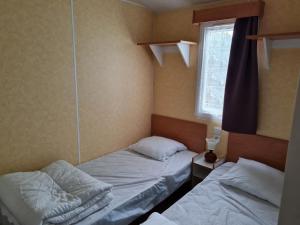 La BétaudièreMobil home sur camping 4 étoiles CAP SOLEIL St Denis d'Oléron的小型客房 - 带2张床和窗户