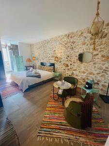 滨海萨纳里Pitibi Maison d'Hote的卧室配有一张床和一张桌子及椅子