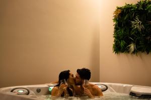 San Demetrio neʼ VestiniVILLA PORRELLI rooms & spa suite的男人和女人在浴缸里亲吻